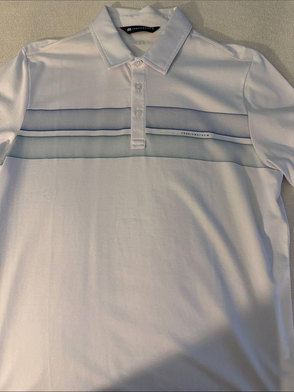 NWOT Travis Mathew White Polo with Blue and Light Teal Stripes